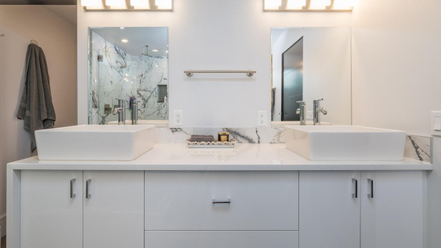 Master Bathroom exemplifies luxury with a large walk in shower, two person tub, views of the woods, double vessel sinks, and separate water closet.